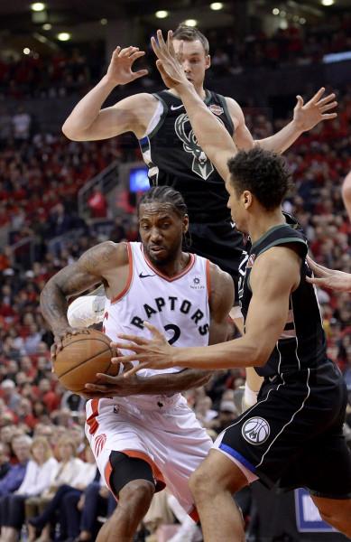 Toronto Raptors forward Kawhi Leonard (2) keeps hold on the ball under pressure from Milwaukee Bucks guard Malcolm Brogdon (13) and teammate Pat Connaughton (24) during second half NBA Eastern Conference finals action in Toronto on Saturday, May 25, 2019. THE CANADIAN PRESS/Nathan Denette