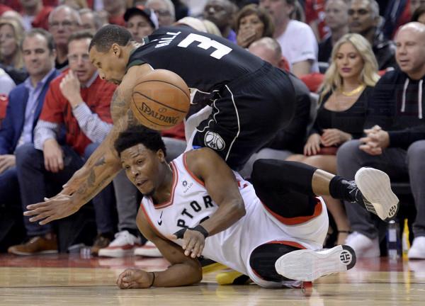Milwaukee Bucks guard George Hill (3) and Toronto Raptors guard Kyle Lowry (7) vie for control of a loose ball during first half NBA Eastern Conference finals action in Toronto on Saturday, May 25, 2019. THE CANADIAN PRESS/Nathan Denette