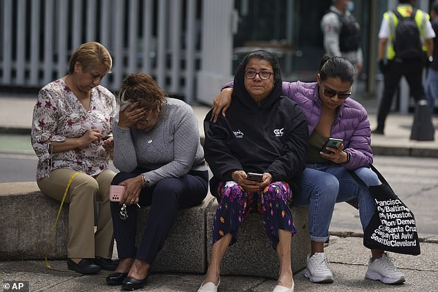 Devastated people gather outside after a magnitude 7.5 earthquake was felt in Mexico City on Monday