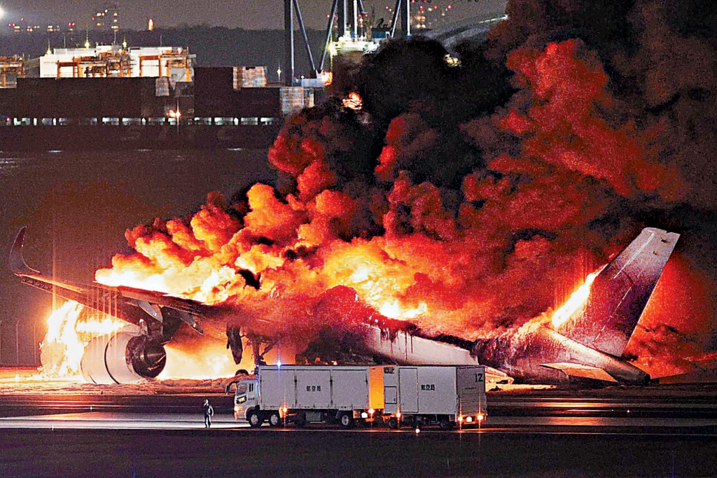 羽田机场跑道上的日航客机被大火吞噬。