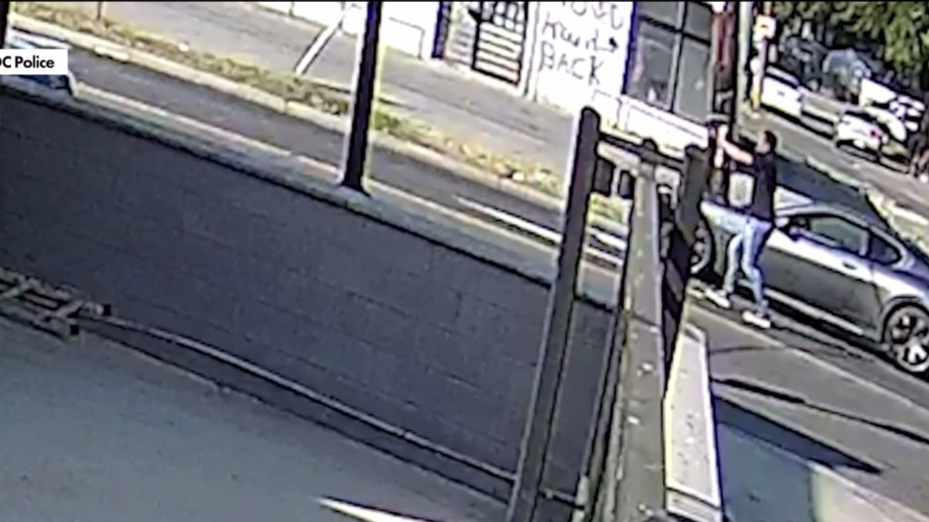 戴维斯边举枪边后退回自己的车。 戴维斯边举枪边后退回自己的车。