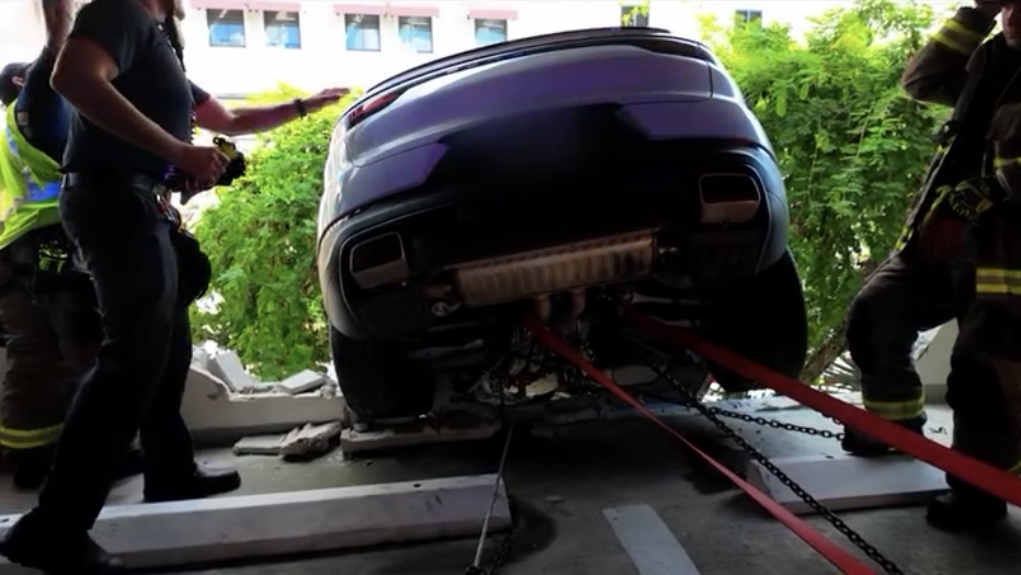 白色保时捷卡在半空中。 Miami Fire Rescue 白色保时捷卡在半空中。 Miami Fire Rescue