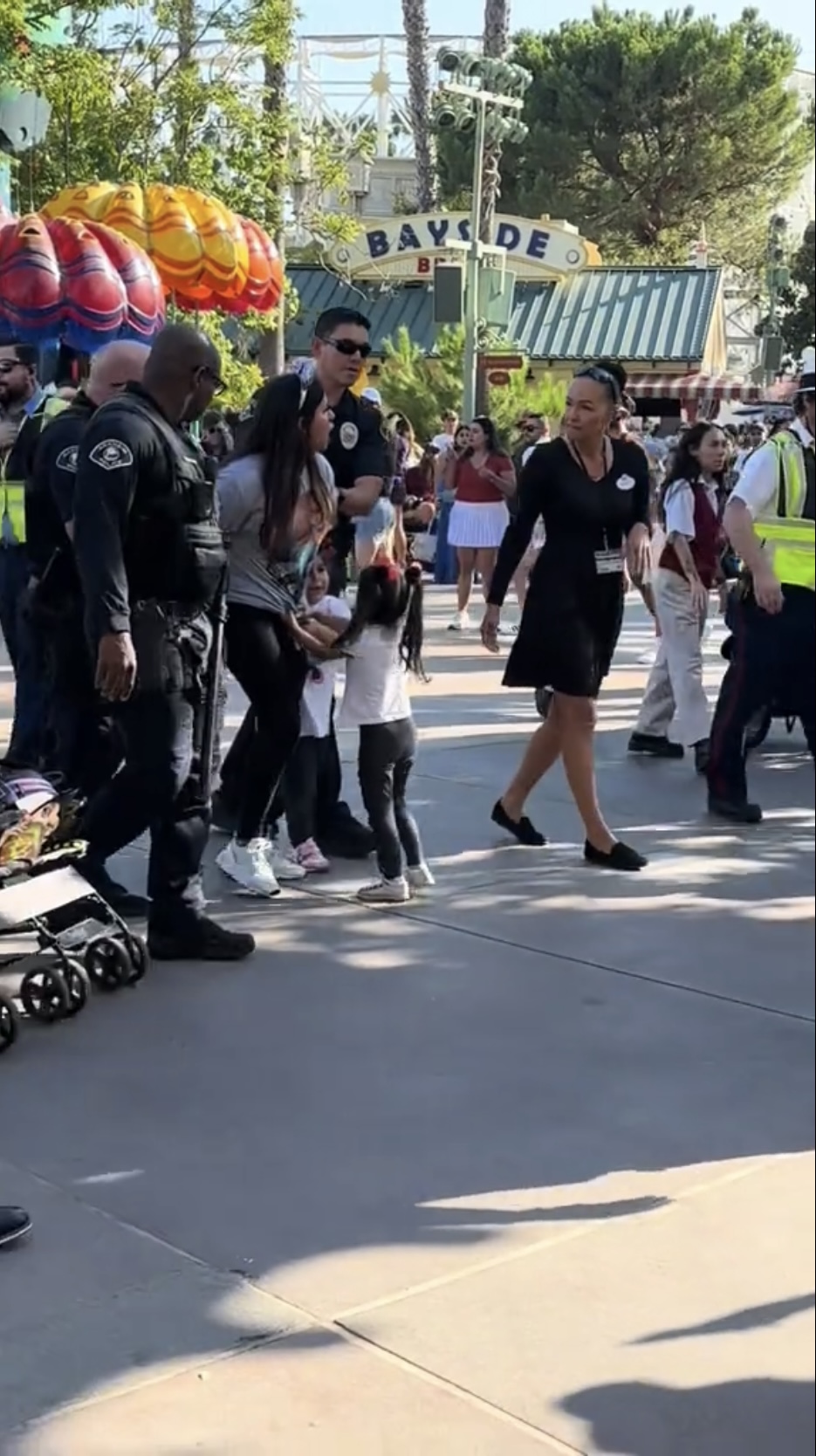 女子被抓住带离迪士尼，2幼女抓着母亲衣角走。
<div class=