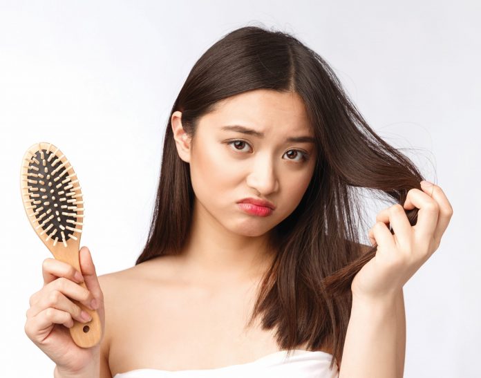 upset-stressed-young-asian-woman-holding-damaged-dry-hair-hands-white-isolated-background-scaled.jpg 图片