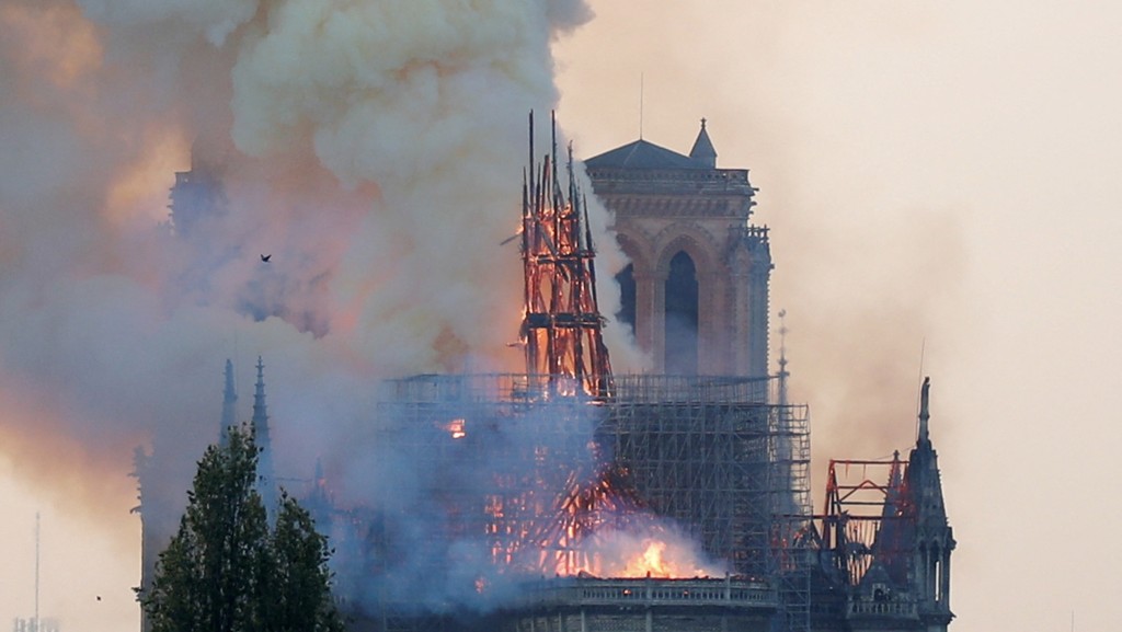 2019年4月15日,全球关注巴黎圣母院的火灾,烟雾从顶部燃烧的尖顶冒起。 路透社 2019年4月15日,全球关注巴黎圣母院的火灾,烟雾从顶部燃烧的尖顶冒起。 路透社